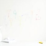 Buntstift von der Wand entfernen – bunte Kreidestriche auf weißer Wand mit Reinigungsmittel
